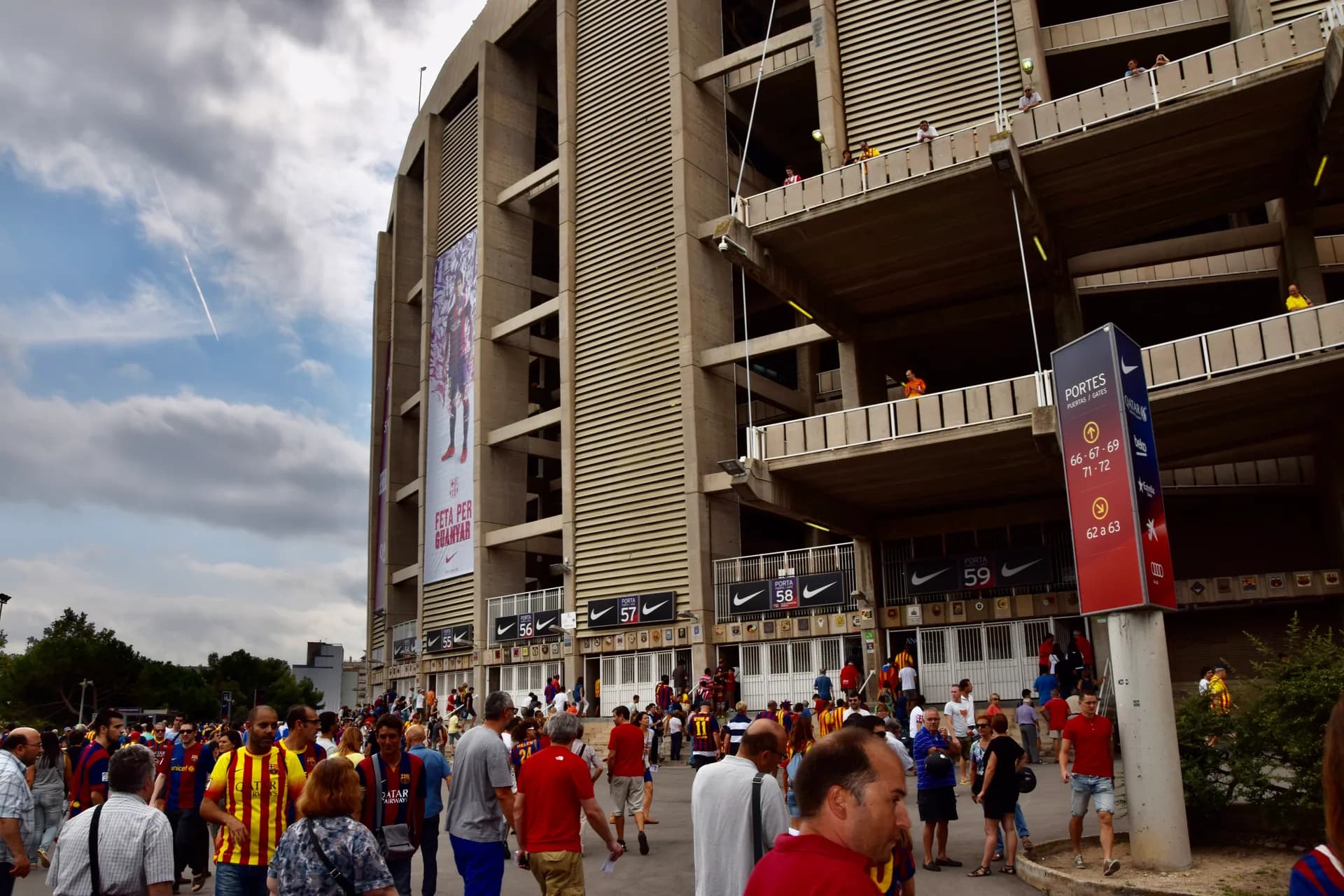 Aficionados con camisetas del Barça frente a las gradas del Camp Nou un día de partido