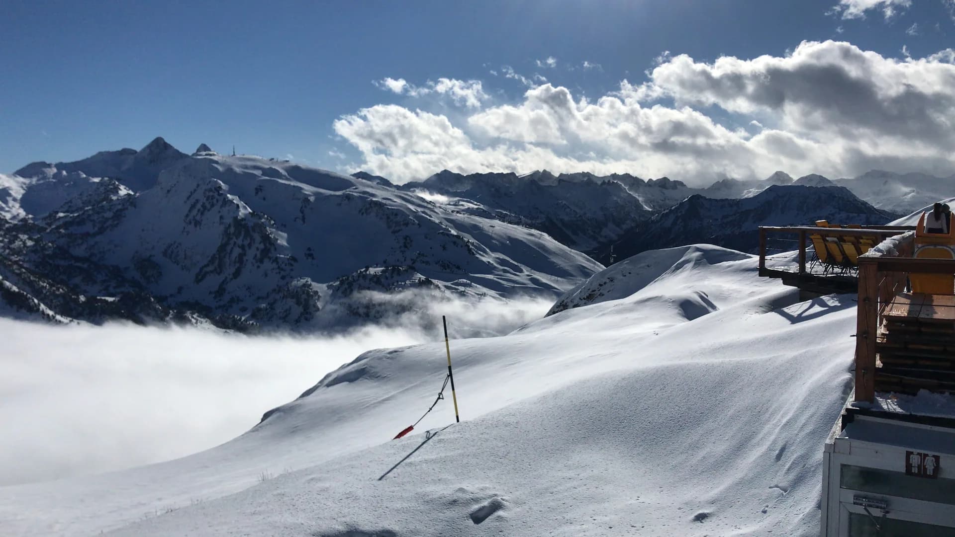Pistes nevades de Baqueira Beret sobre un mar de núvols, amb les muntanyes de l'Aran al fons