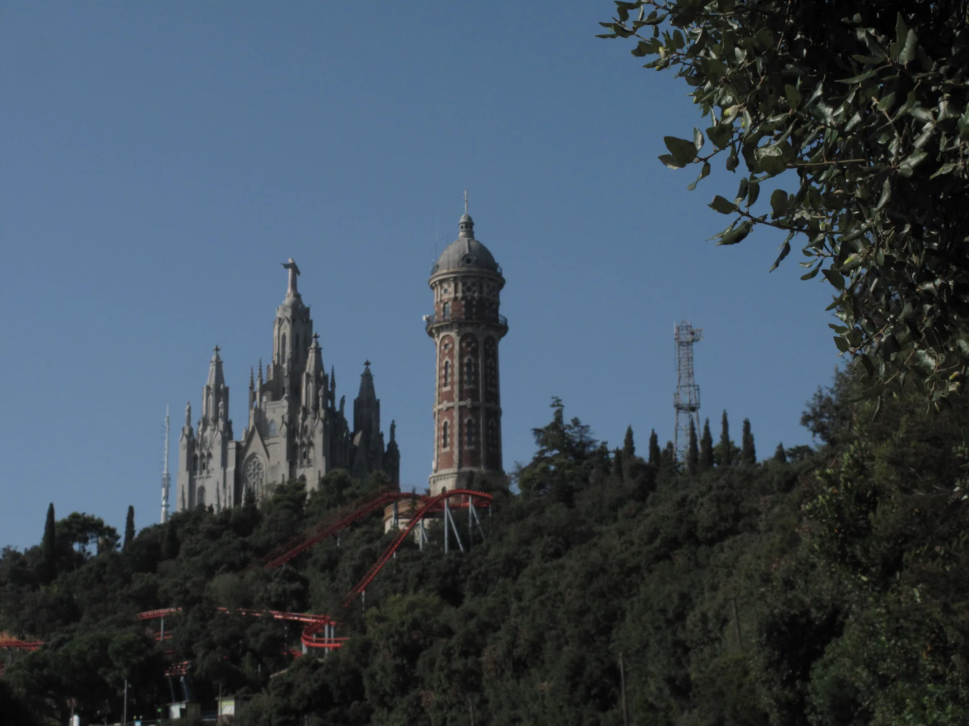 El Sagrat Cor i una torre del parc al cim del Tibidabo, entre el bosc